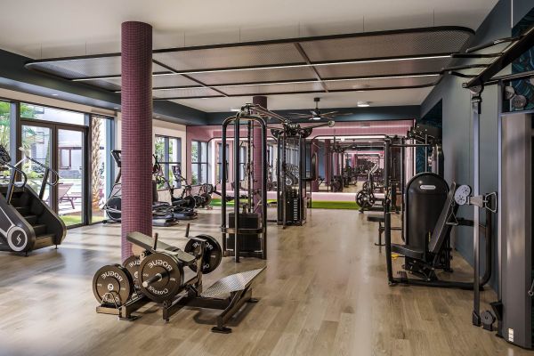 Spacious, modern fitness center at VERVE Orlando featuring strength training equipment, cardio machines, mirrored walls, and natural light—designed to support an active student lifestyle.