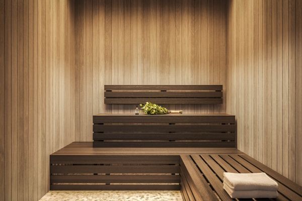 Modern wood-paneled sauna at VERVE Orlando featuring tiered bench seating, warm ambient lighting, and a serene, spa-like atmosphere for rest and recovery.