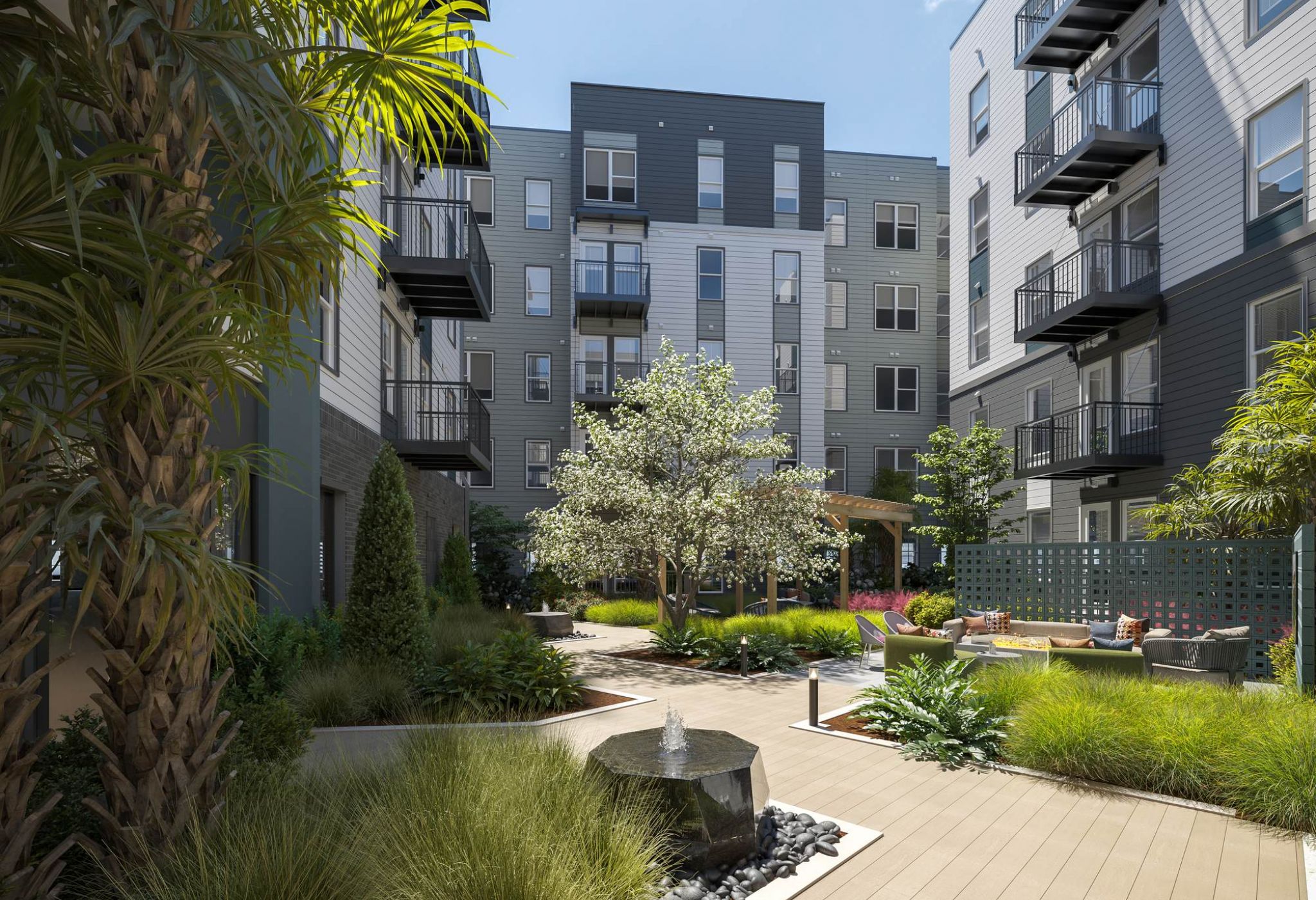 Tranquilo patio exterior en VERVE Orlando con exuberantes jardines, modernos balcones en los apartamentos, senderos para pasear y una fuente central, ideal para relajarse o ponerse al día con los amigos.
