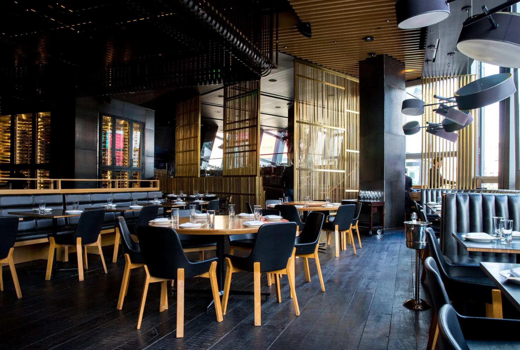 Interior de restaurante con varias mesas y asientos tipo reservado.