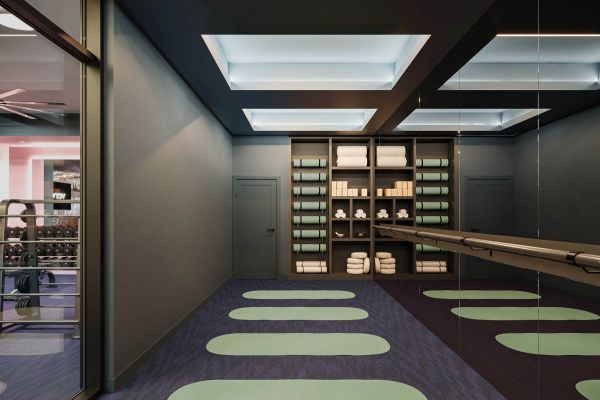 Serene yoga and wellness studio at VERVE Orlando featuring soft lighting, green floor mats, mirrored walls, and calming design elements—ideal for stretching, meditation, or low-impact workouts.